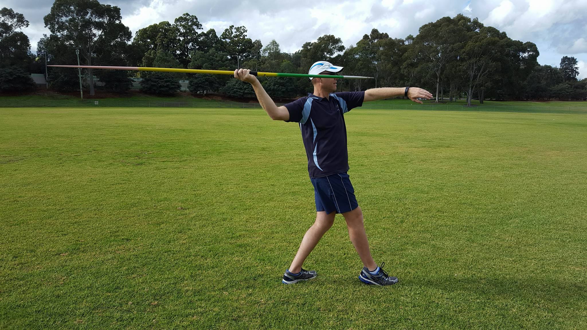 Right-handed javelin thrower standing with right foot forward - side view
